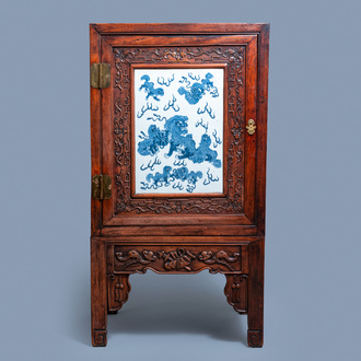 Een Chinese hongmu houten kast met een blauw-witte 'boeddhistische leeuwen' plaquette, 19e eeuw